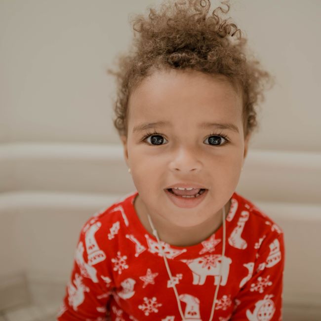 A smiling toddler in christmas pyjamas