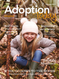 Adoption Today magazine cover of a little girl in autumn sitting outside smiling