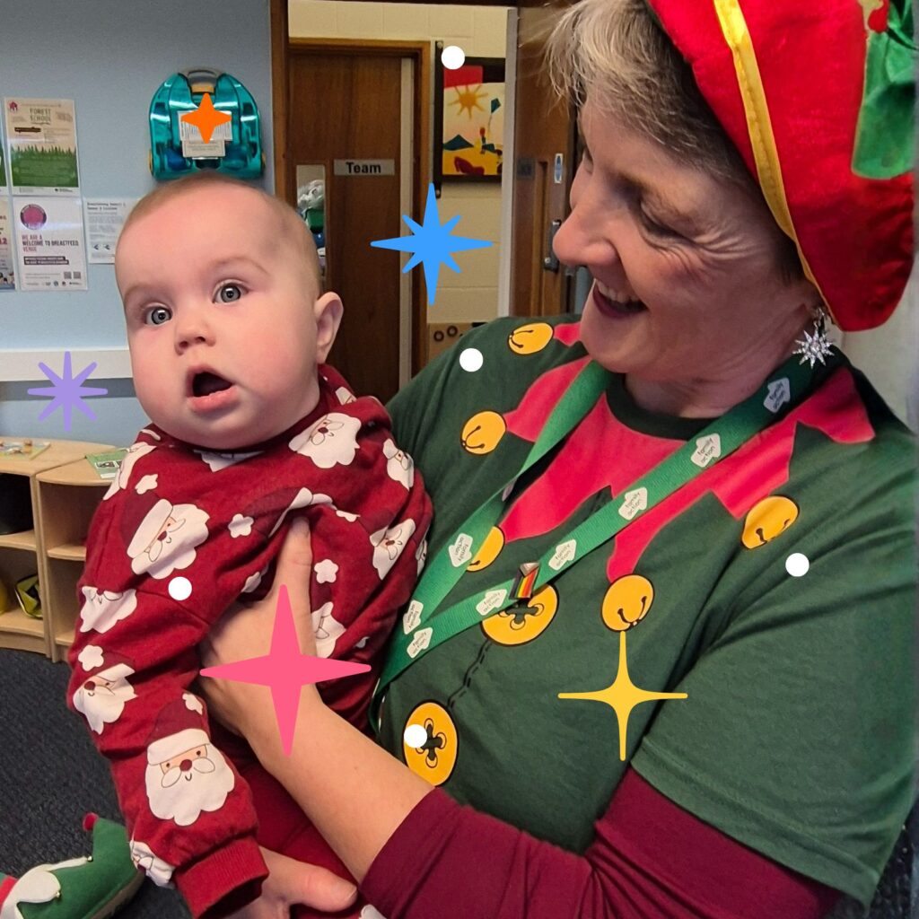 Family Action staff holding a baby both wearing christmas outfits