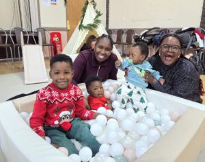 A family of 4 children and a mum enjoying Christmas celebrations in a ball pit at Family Action's Medway Universal Parenting service
