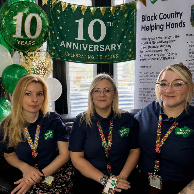 The Helping Hands team - three women - sitting in front of green and gold 10th Anniversary balloons and banners
